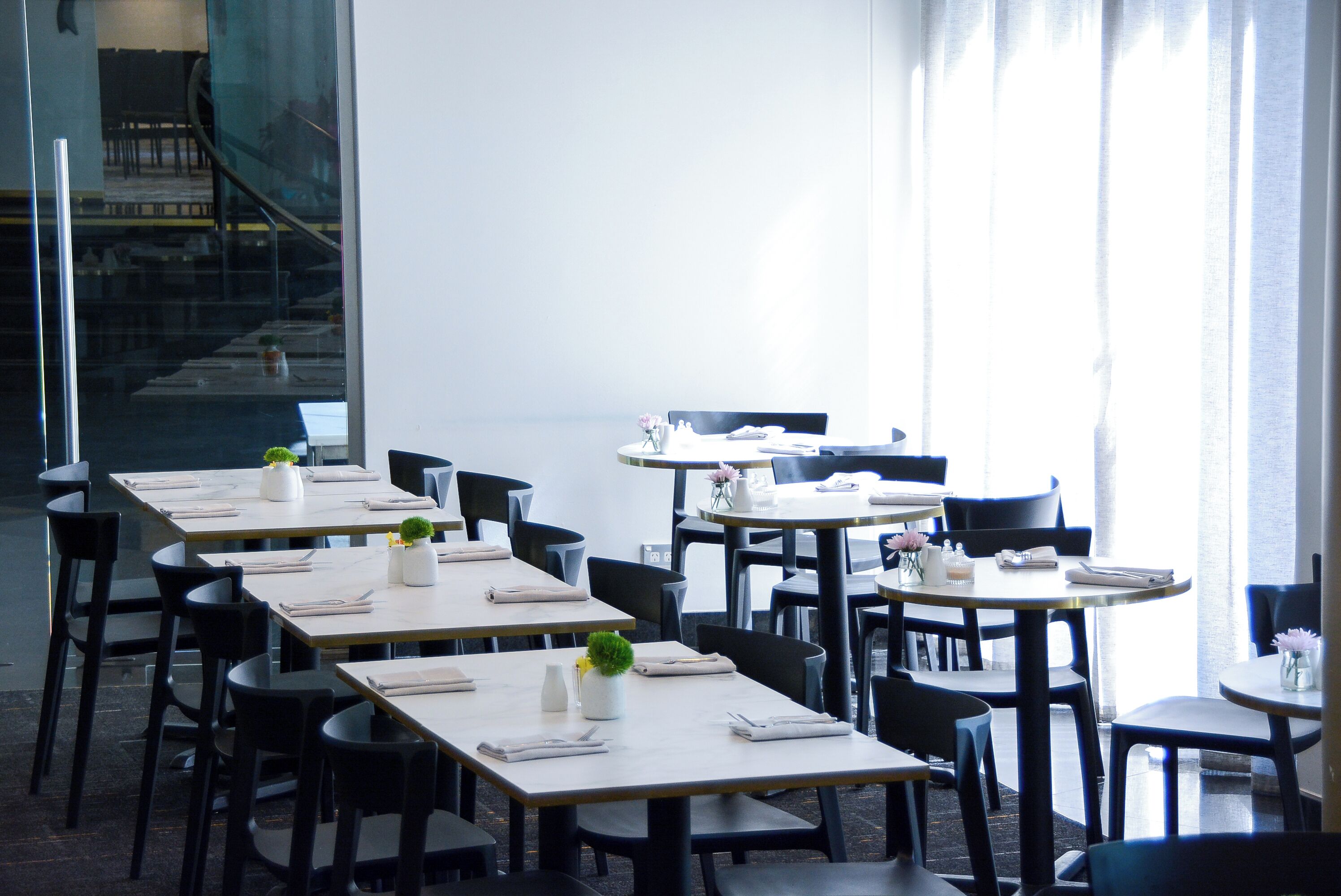 Ein modernes Restaurant mit mehreren Tischen und Stühlen, ansprechend und großzügig gestaltet.