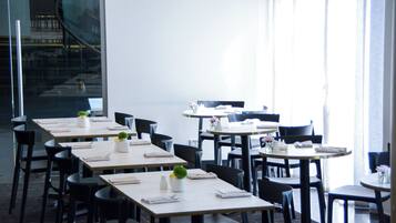 Ein modernes Restaurant mit mehreren Tischen und Stühlen, ansprechend und großzügig gestaltet.