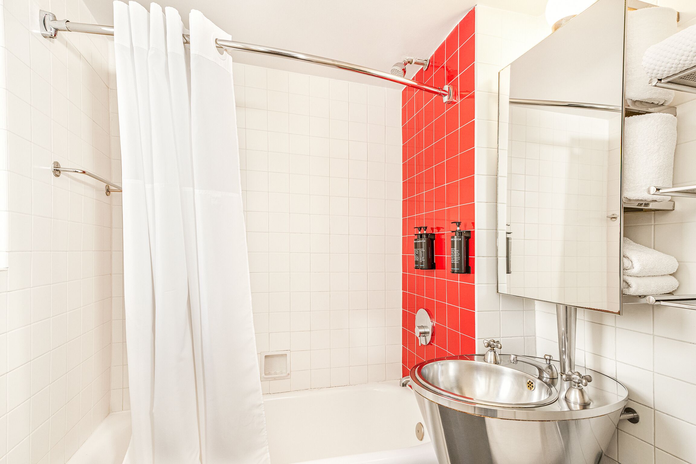 A bathroom with a shower, a sink, and a mirror.