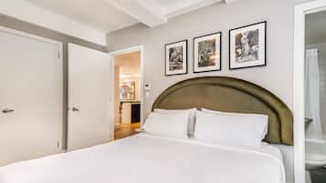 A bedroom with a large bed, a wooden headboard, and three framed pictures on the wall.