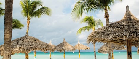 On the beach, white sand, beach cabanas, sun-loungers