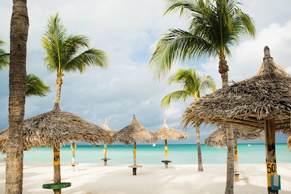 On the beach, white sand, beach cabanas, sun loungers