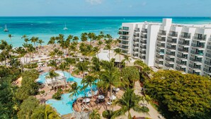 A resort with a pool, palm trees, and a view of the ocean. - Aruba Marriott Resort & Stellaris Casino (Noord)