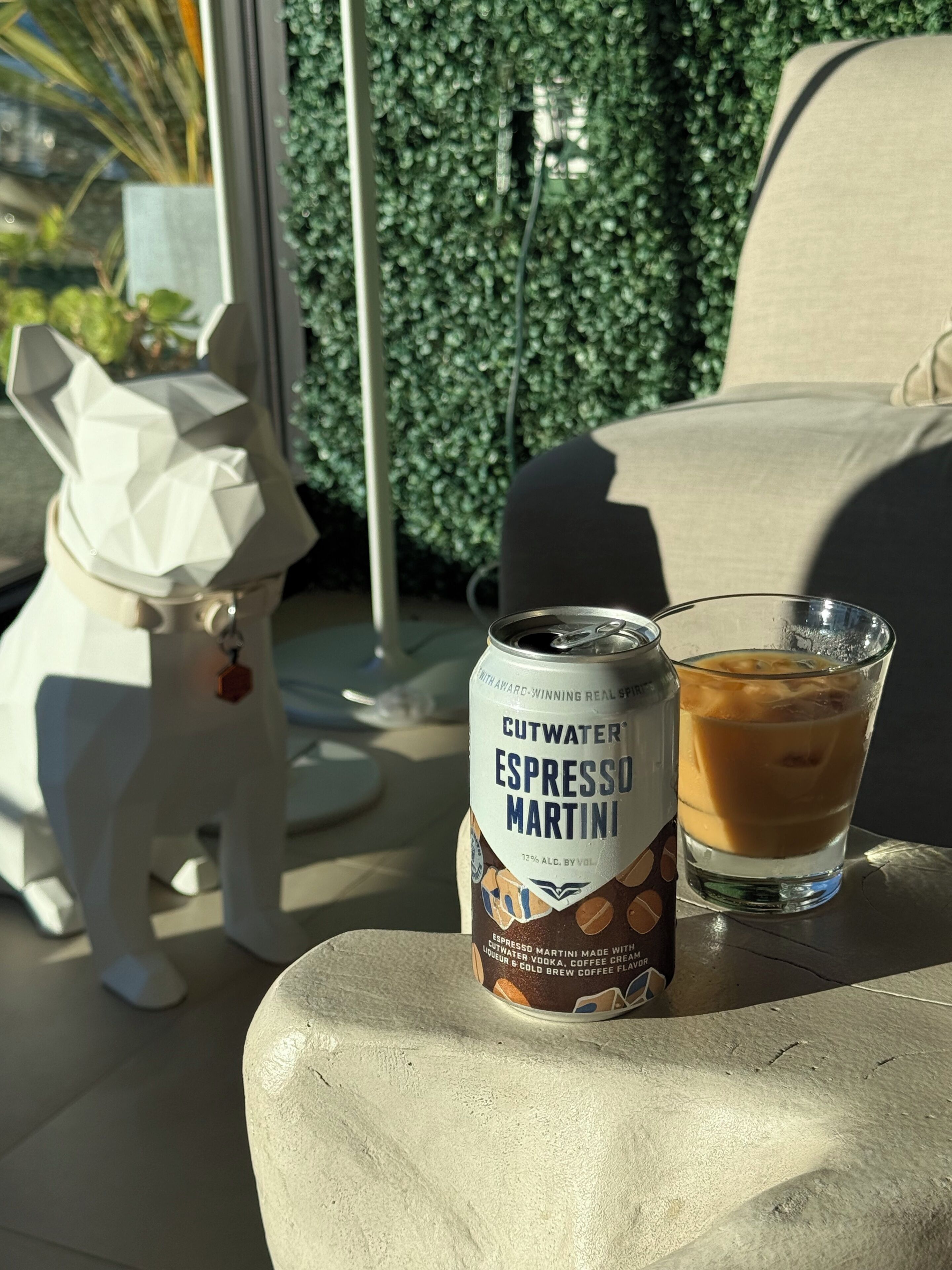 Uma lata de Cutwater Espresso Martini e um copo de café gelado sobre uma mesa.