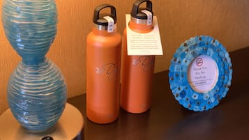 Een blauwe vaas, twee oranje waterflessen en een blauwe onderzetter met een rookverbodsbord.