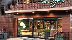 A modern storefront with a neon sign reading "The Dylan."