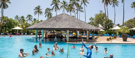 Una piscina al aire libre, sombrillas, sillones reclinables de piscina