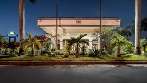 A hotel with a flat roof, palm trees, and a Days Inn sign. - Days Inn by Wyndham Florida City (Florida City)