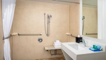 A bathroom with a shower, grab bars, a sink, and a mirror.