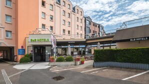 Un hotel B&B con una fachada moderna, zona de estar al aire libre y un jardín bien cuidado.