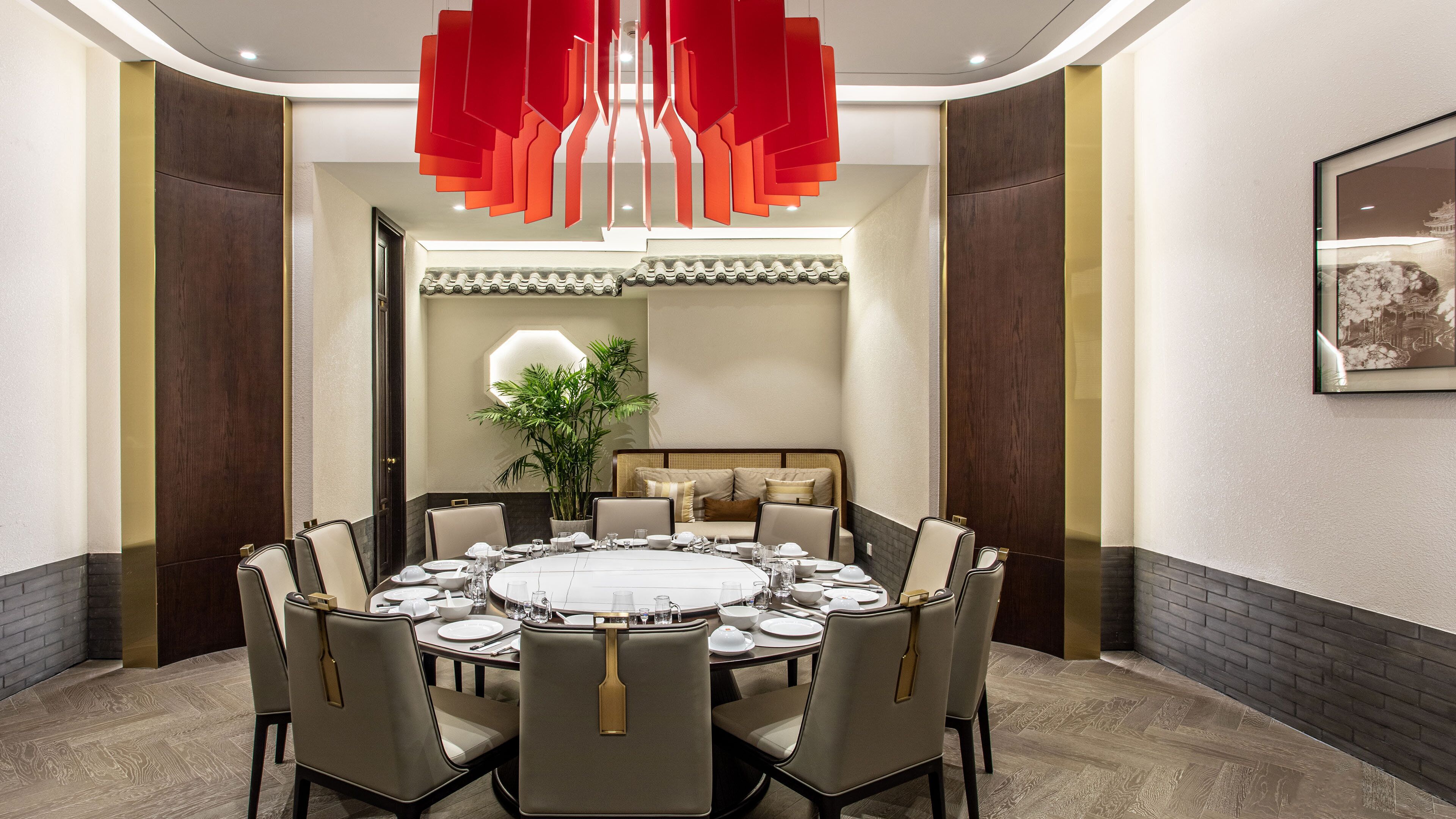 A dining room with a round table set for six, surrounded by upholstered chairs.