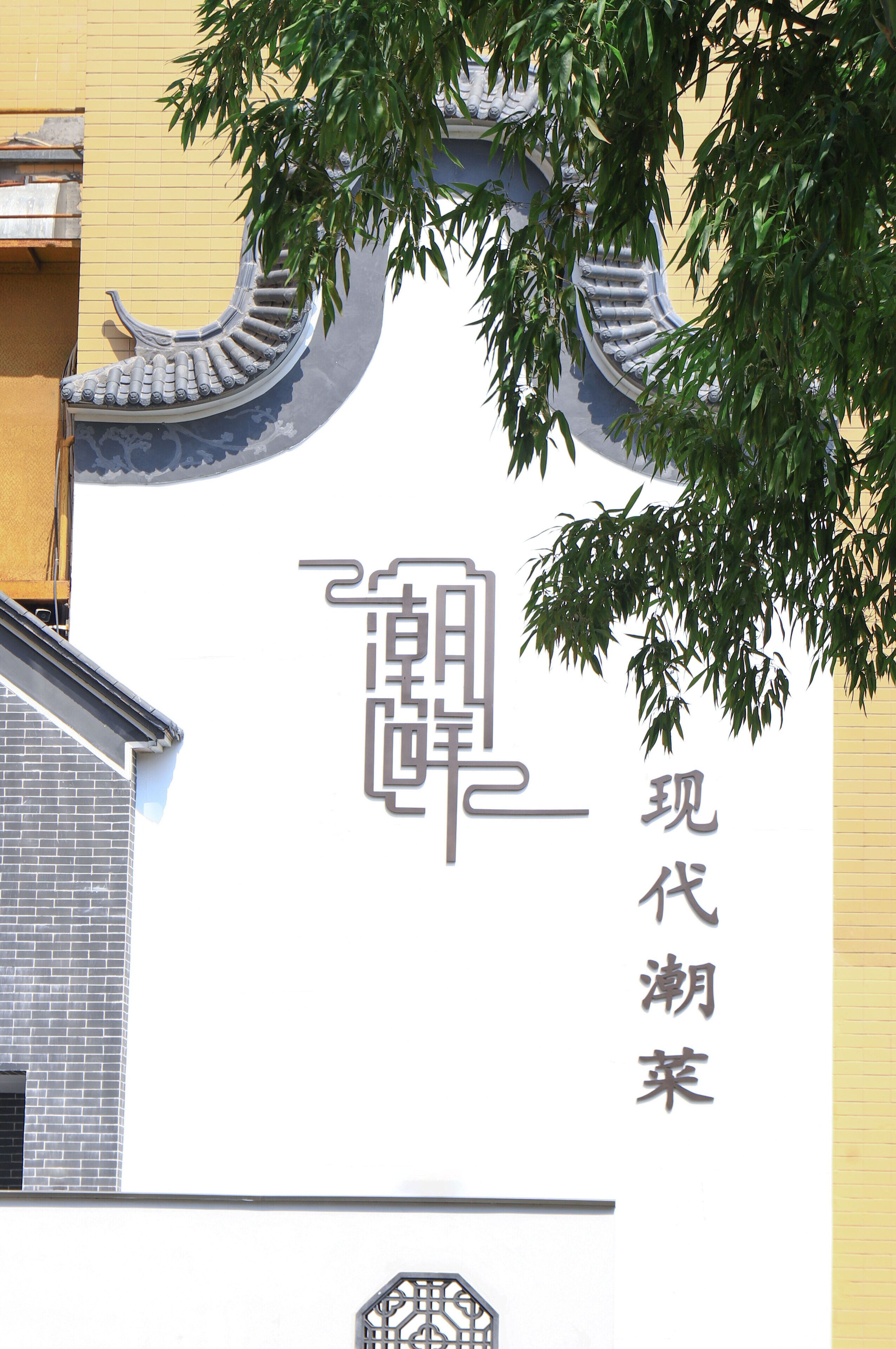 Un edificio con elementos arquitectónicos tradicionales chinos, como tejas curvas y una puerta decorativa.