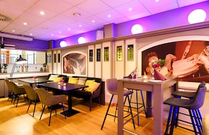 Een moderne eethoek met een bar, zitplaatsen en een groot muurdecor.
