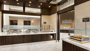 A buffet area with a glass display case, a hot buffets sign, and a bakery & toast sign. - Embassy Suites by Hilton Brea North Orange County (Brea)