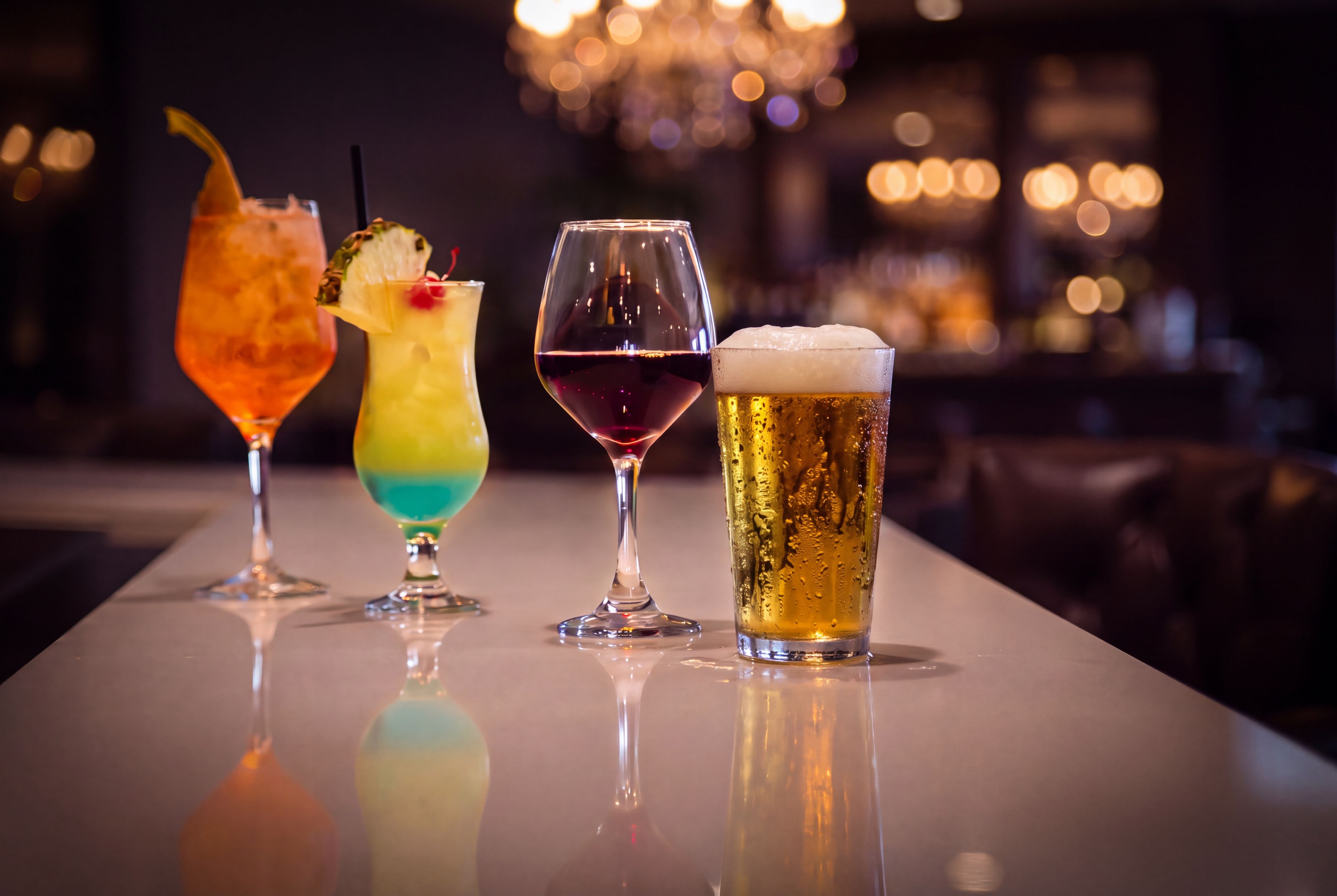 Un bar avec quatre boissons différentes servies dans des verres.