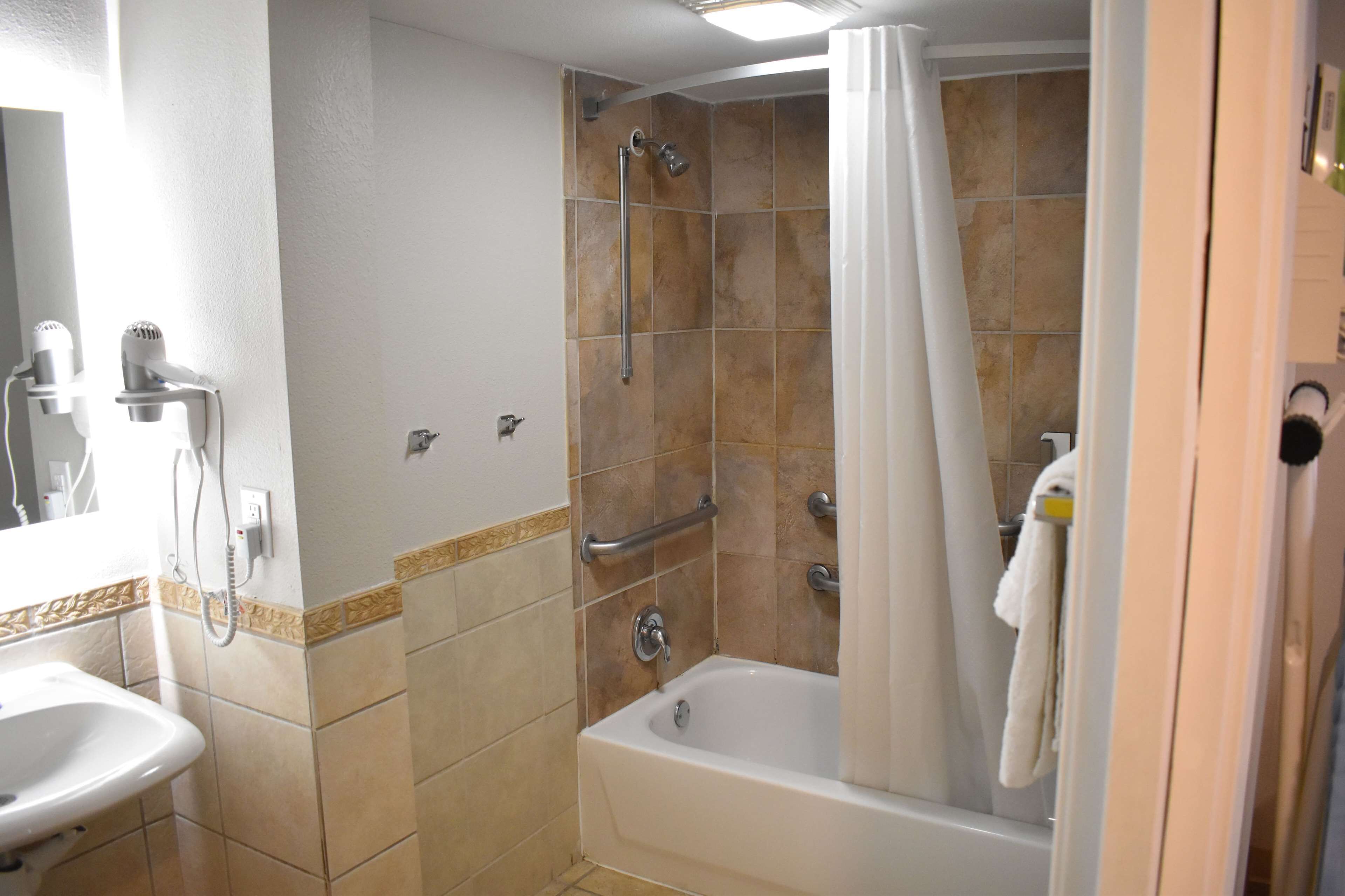 A bathroom with a bathtub, shower, and sink.