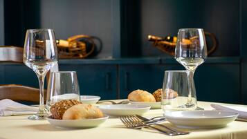 A table set with wine glasses, plates of bread, and cutlery.