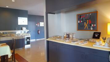 Una habitación de hotel moderna con kitchenette, comedor y sala de estar.