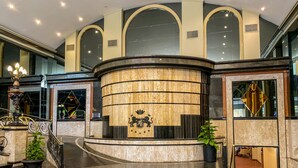 A spacious lobby with a marble reception desk, a grand staircase, and a chandelier. - Nobile Suites Excelsior Asuncion (Asunción)