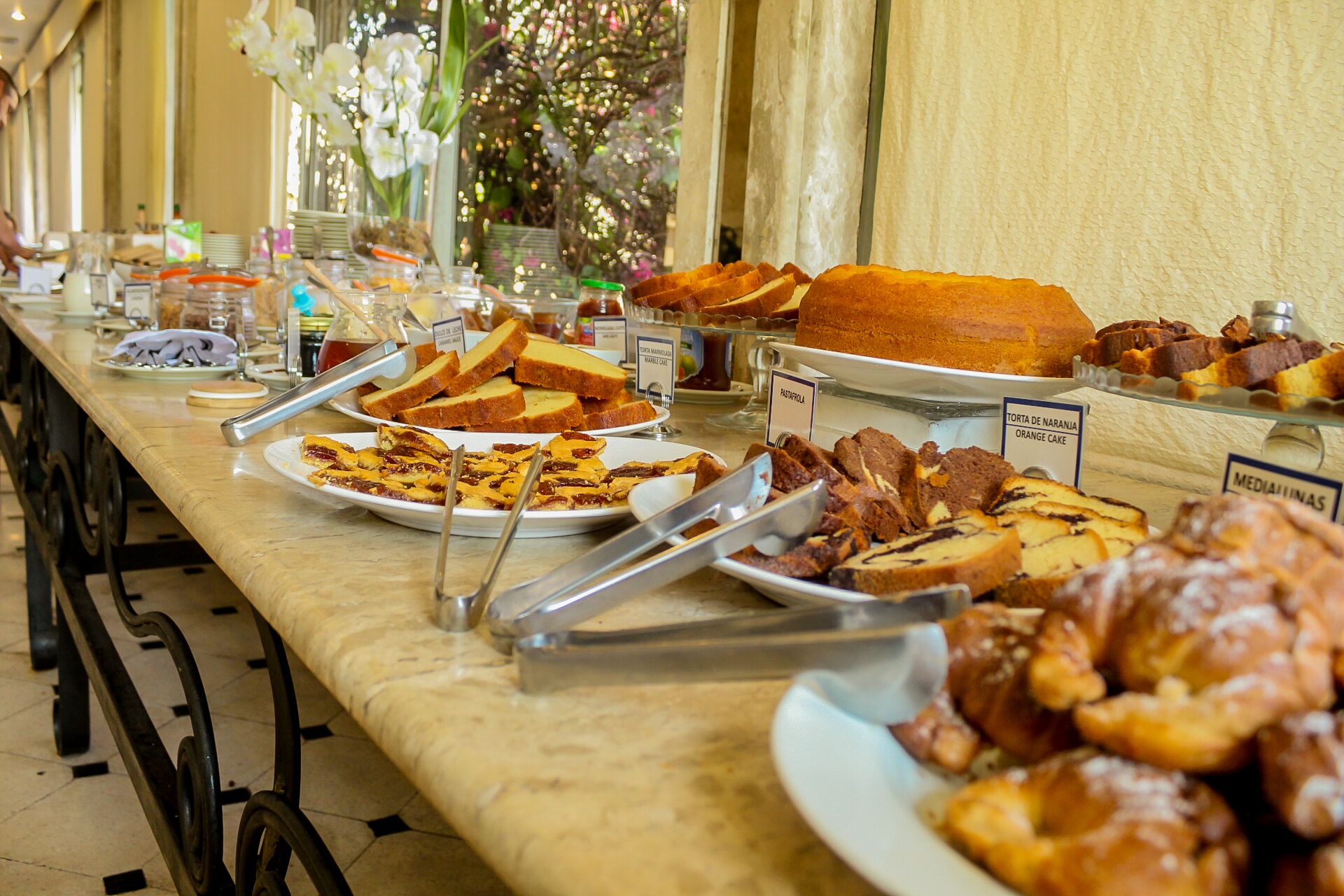 Ein Buffet mit verschiedenen Speisen, darunter Brot, Gebäck und Kuchen.