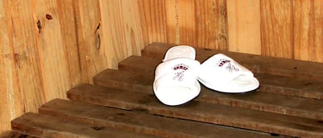 Una sauna de madera con bancos y un banco con una toalla y zapatos.