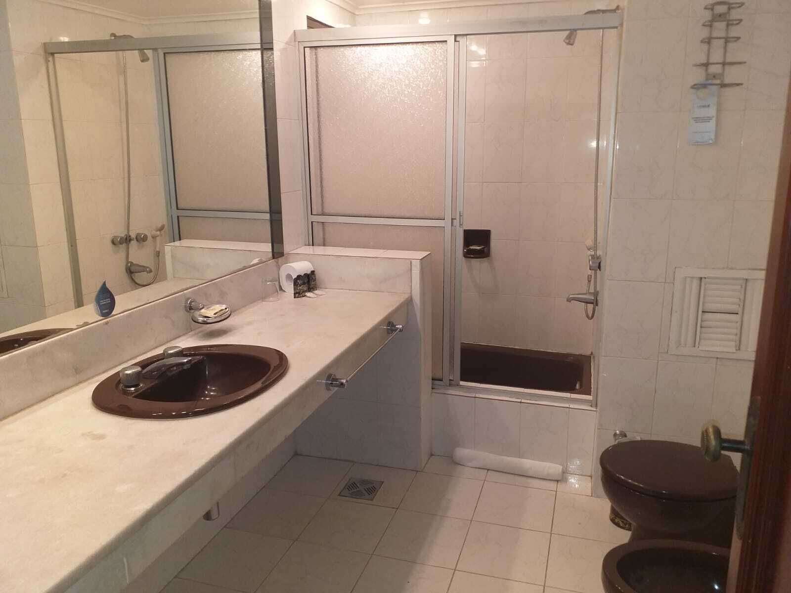 Un baño con lavabo, espejo, inodoro y ducha.