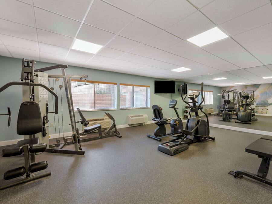 Une salle de sport équipée de divers appareils d’exercice, notamment des appareils de musculation, des tapis de course et des vélos d’appartement.