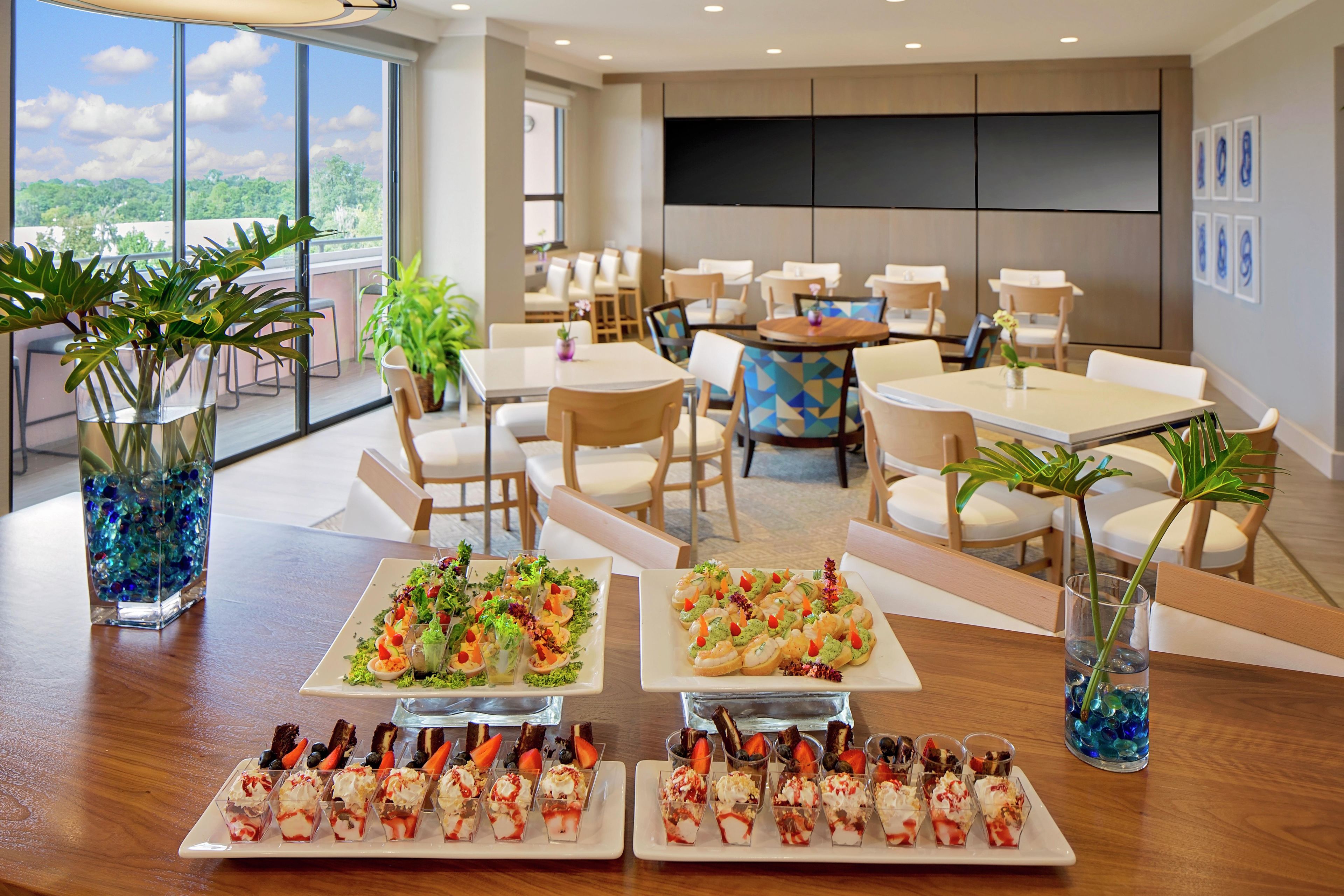A dining area with multiple tables, chairs, and a variety of food displays.
