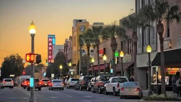 A street lined with palm trees and buildings with neon signs, including a Marriott hotel.