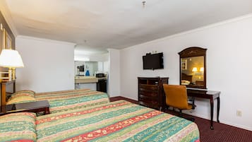 A hotel room with two beds, a desk, a chair, a television, and a mirror.