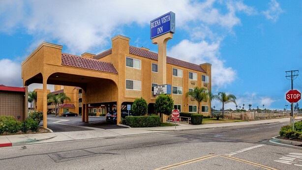 A Buena Vista Inn with a prominent sign, a covered entrance, and a stop sign nearby. - Buena Vista Inn (Anaheim)