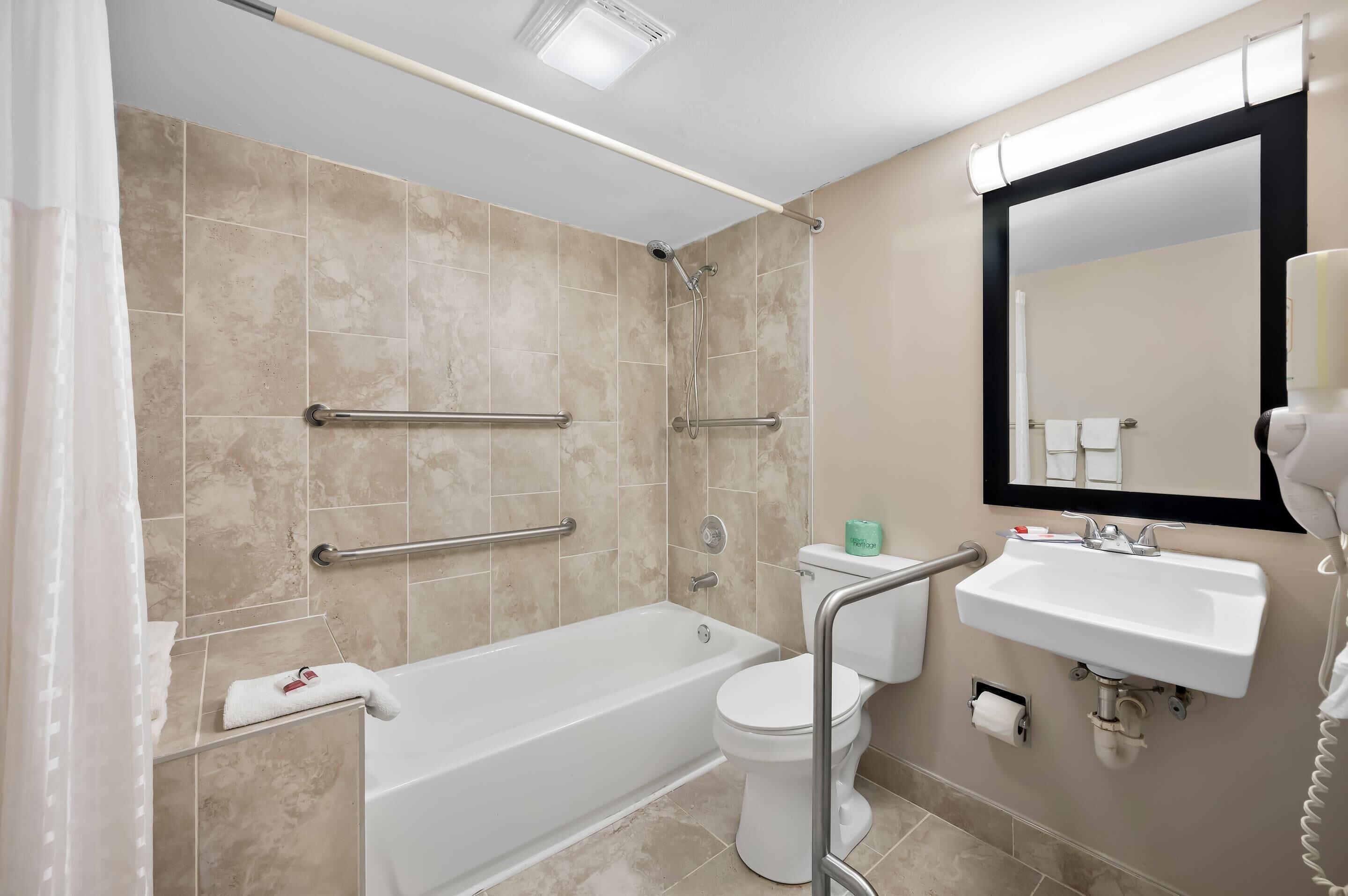 A modern bathroom with a bathtub, toilet, and sink.