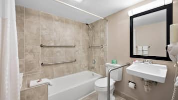 A modern bathroom with a bathtub, toilet, and sink.