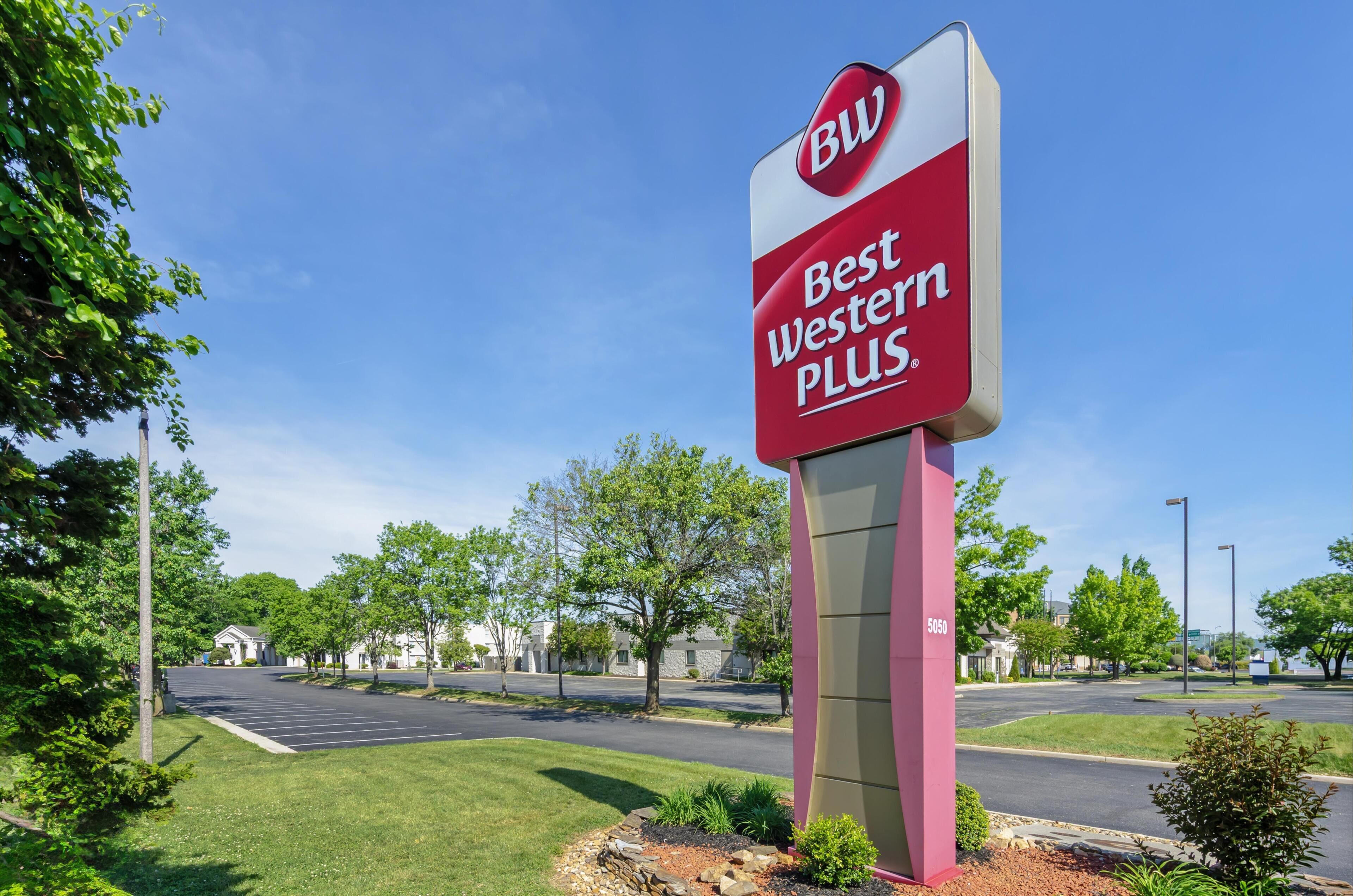 Señal de Best Western PLUS visible, con vista clara al estacionamiento y la vegetación circundante.
