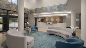 A hotel reception area with a curved sofa, a blue armchair, and a reception desk.