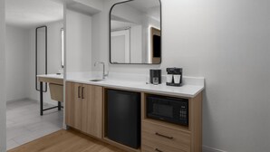 A modern kitchen with a dishwasher, microwave, and coffee maker. - Embassy Suites by Hilton Orlando International Dr ICON Park (Orlando)