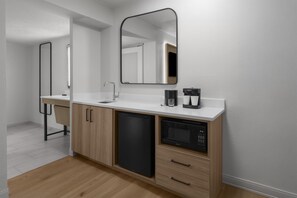 A modern kitchen with a dishwasher, microwave, and coffee maker. - Embassy Suites by Hilton Orlando International Dr ICON Park (Orlando)