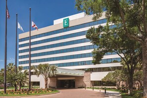 A modern hotel with a prominent 'E' logo, multiple floors, and a covered entrance.