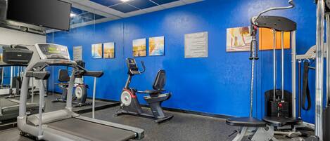 A gym with treadmills, stationary bikes, and weight machines.