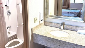 A bathroom with a toilet, sink, and mirror. - Red Roof Inn Washington DC - Columbia/ Fort Meade (Jessup)