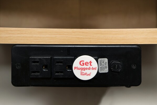 A power strip with a plug-in button that says "Get Plugged-In! RedRoof."