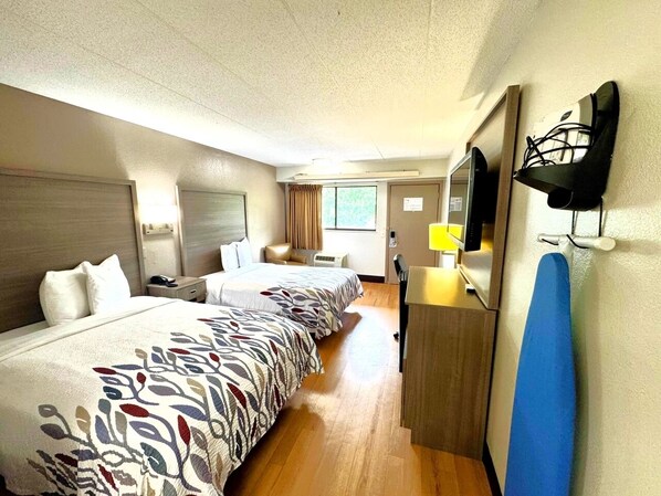 A hotel room with two beds, a desk, a TV, and a mirror. - Red Roof Inn Washington DC - Columbia/ Fort Meade (Jessup)