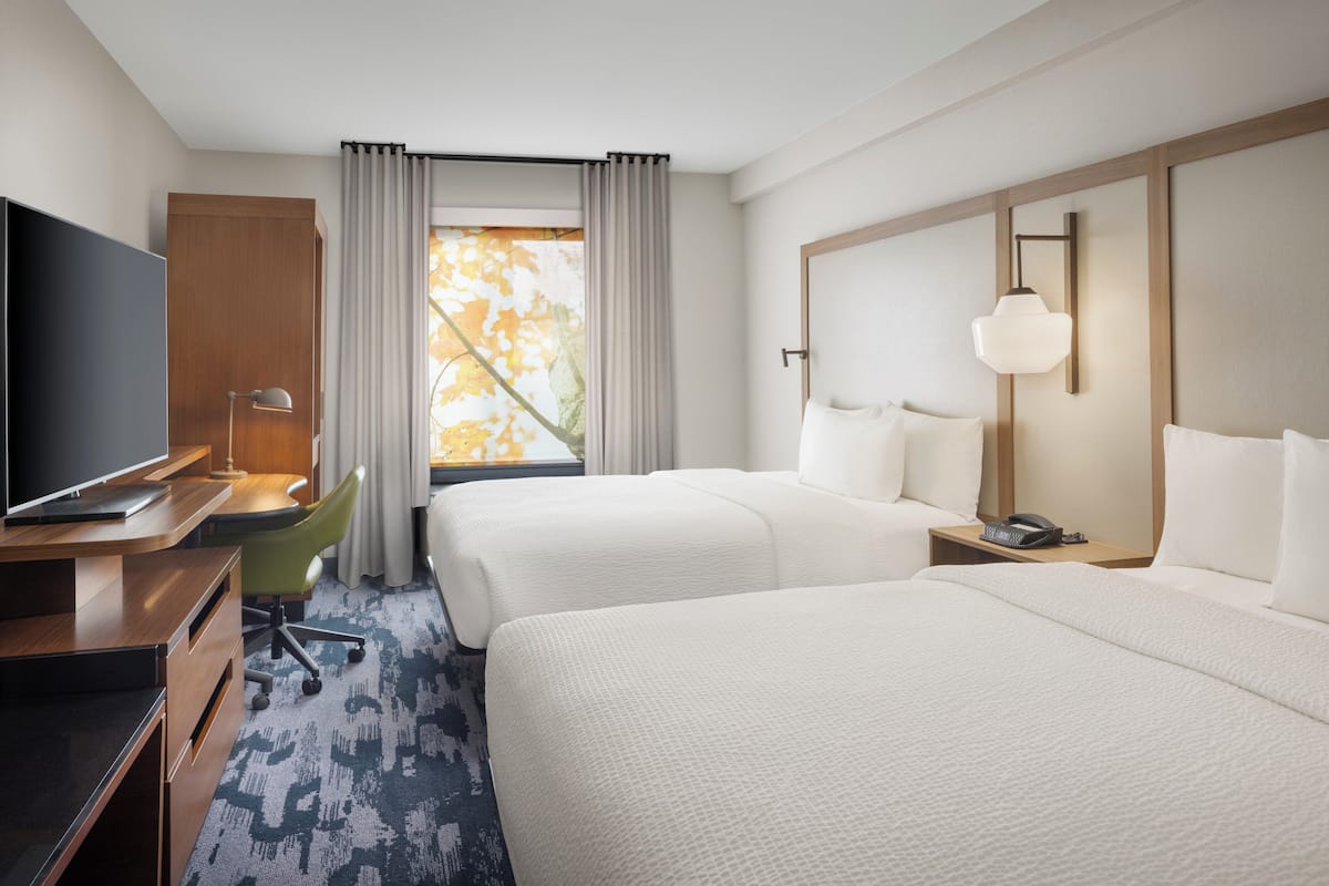 Edredón, escritorio, cortinas blackout y tabla de planchar con plancha