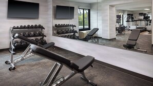Een sportschool met gewichthefapparatuur, dumbbells en cardioapparaten.