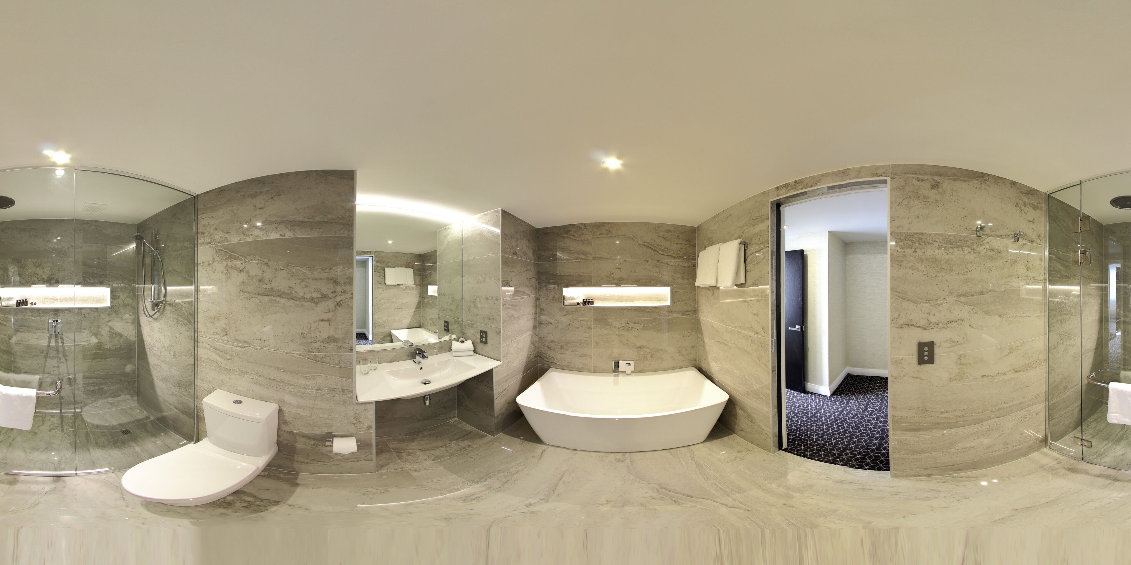 A modern bathroom with a glass-enclosed shower, a toilet, a sink, and a freestanding bathtub.