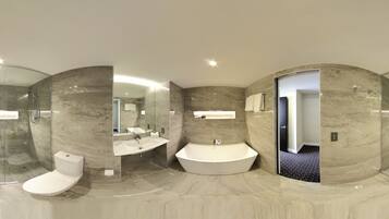 A modern bathroom with a glass-enclosed shower, a toilet, a sink, and a freestanding bathtub.