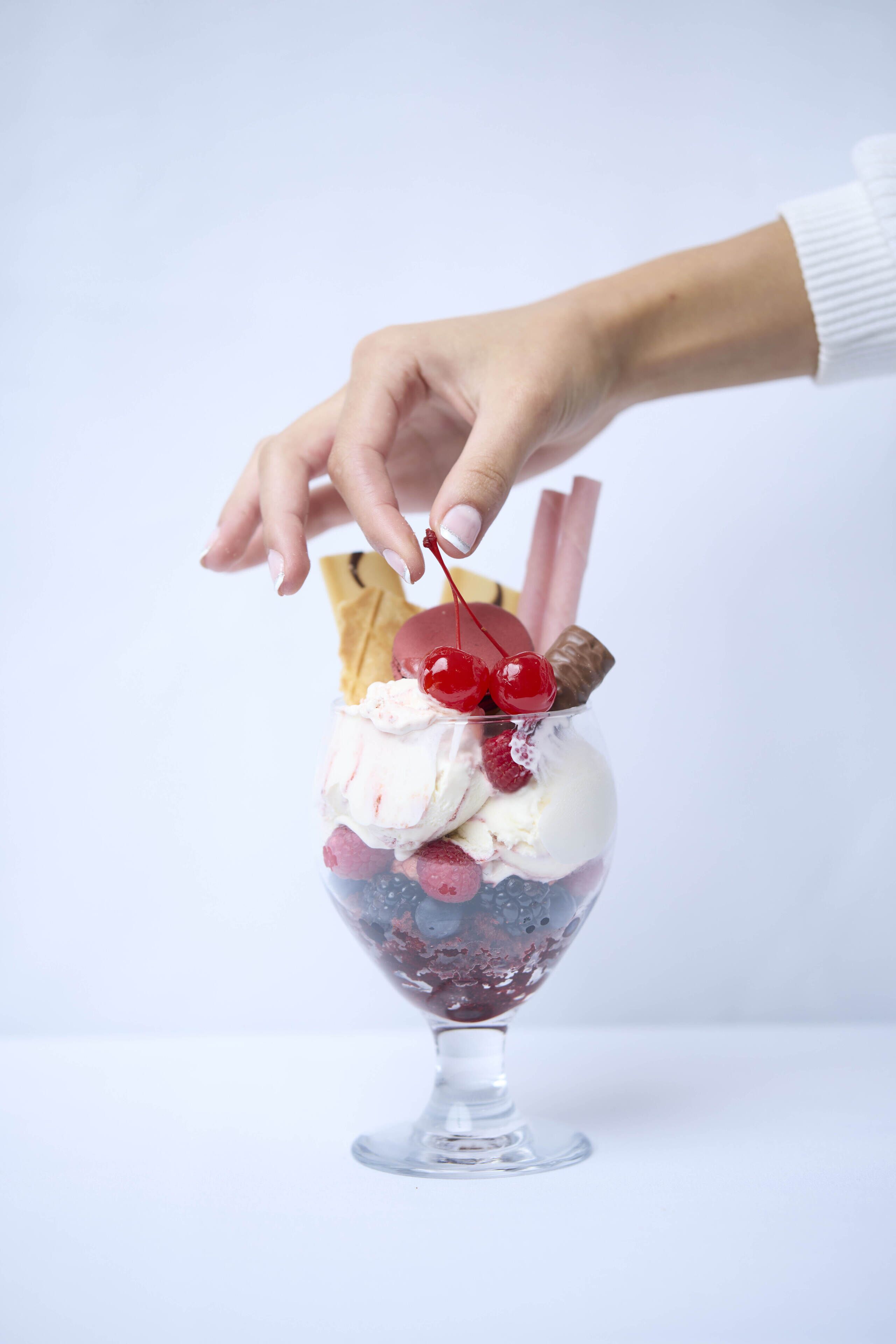 Un dessert servi dans un bol en verre, agrément é de divers accompagnements.