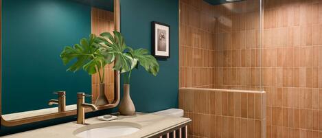 A modern bathroom with a large mirror, two sinks, a toilet, and a shower area.