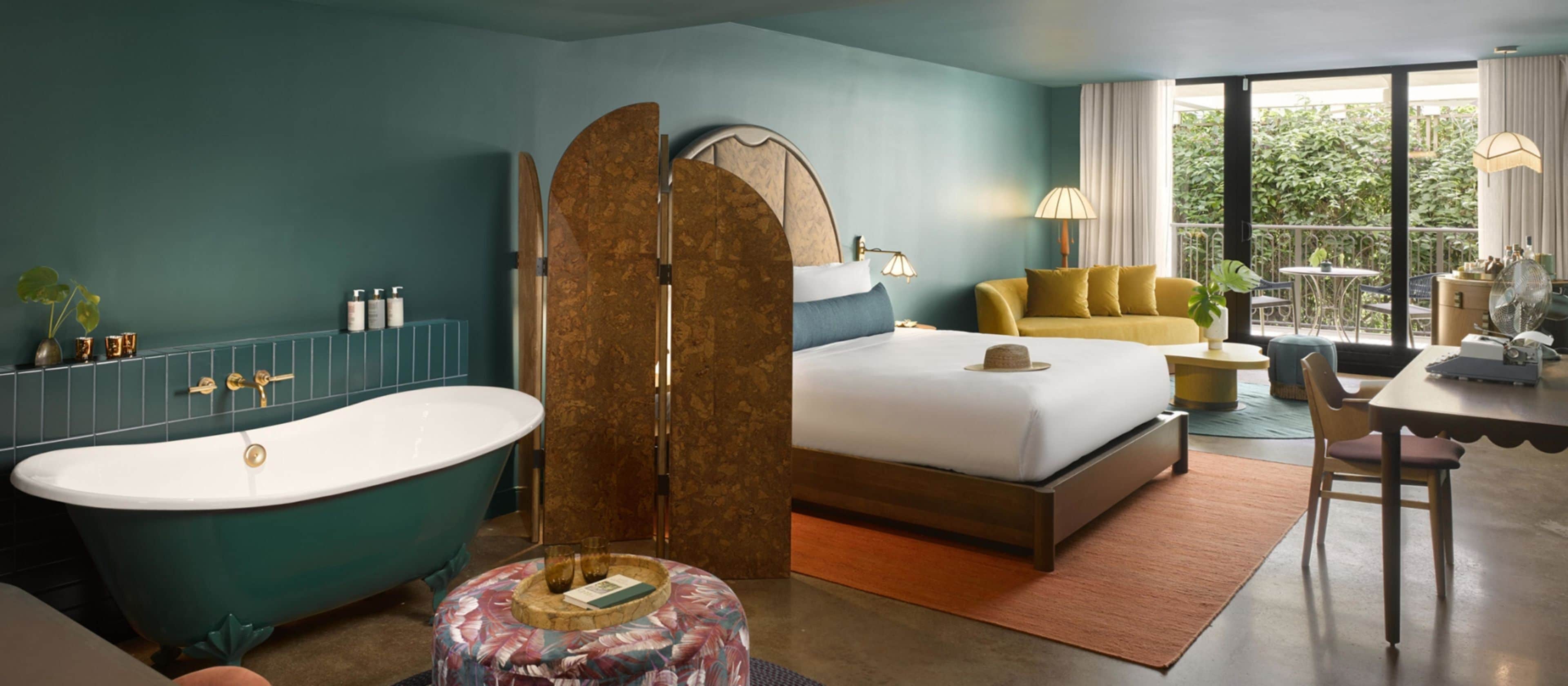 Ein Schlafzimmer mit Badewanne, einem Bett, einer Couch und einem Essbereich.