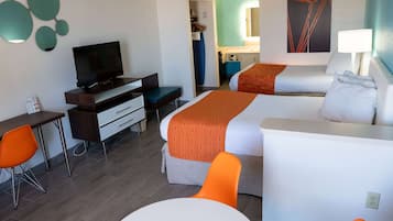 Habitació d'hotel amb televisió, dos llits, escriptori i cadira.